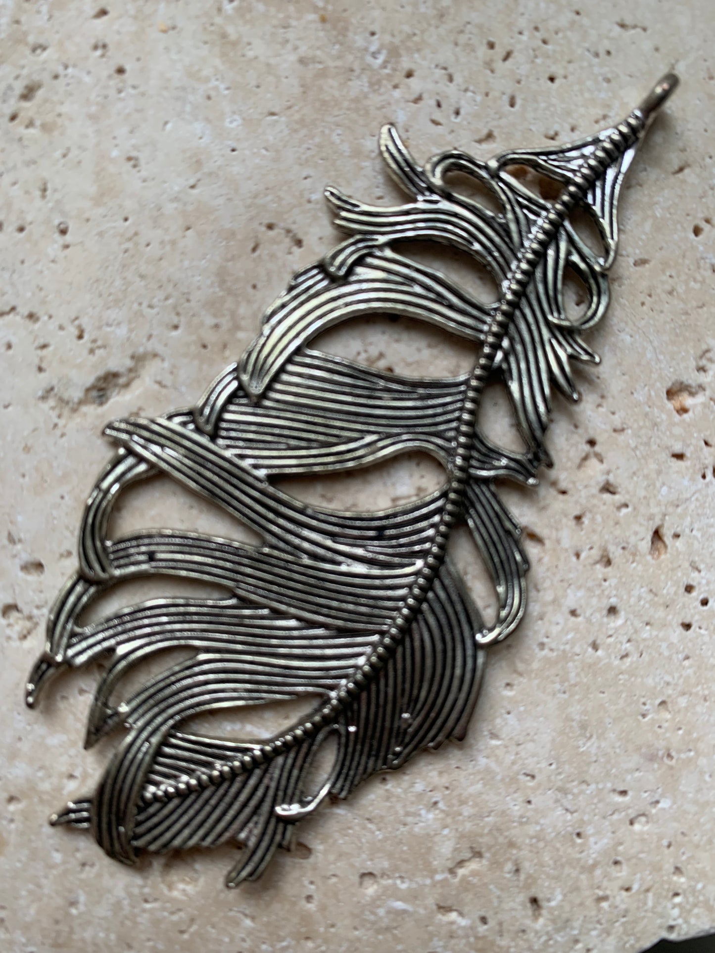 Pendentif en métal argenté en forme de plume. De 85 x 40 x 5 millimètres. Vendu avec cordon noir réglable offert, parfait !