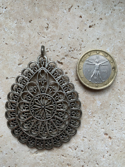 Pendentif en métal argenté en forme de Mandala. De 60 x 44 x 5 millimètres. Vendu avec cordon noir réglable offert, parfait !