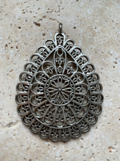 Pendentif en métal argenté en forme de Mandala. De 60 x 44 x 5 millimètres. Vendu avec cordon noir réglable offert, parfait !