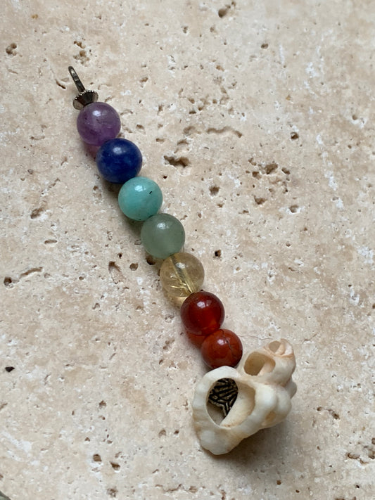 Pendentif '7 chakras' fait par Gem & Zen, au choix : 7 perles avec un coquillage naturel ou sans ! De 52 millimètres de hauteur x 6 millimètres de diamètre. Vendu avec cordon réglable de couleur noire !