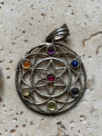 Pendentif '7 chakras' de 35 millimètres de diamètre, en métal argenté (laiton). Vendu avec cordon réglable de couleur noire !