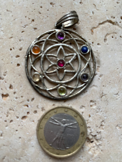 Pendentif '7 chakras' de 35 millimètres de diamètre, en métal argenté (laiton). Vendu avec cordon réglable de couleur noire !