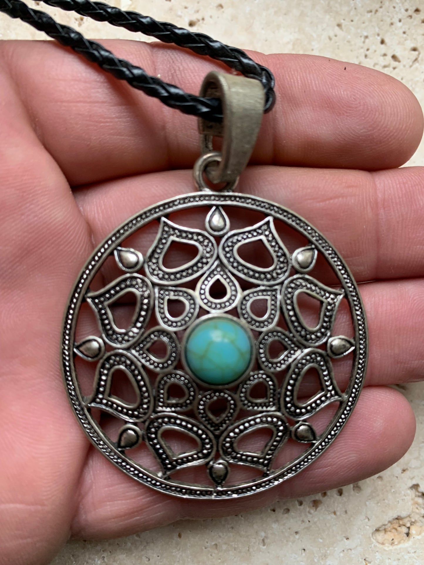 Pendentif en métal argenté en forme de Mandala avec cabochon d'howlite bleue au centre. De 48 x 12 millimètres. Vendu avec cordon noir réglable offert, parfait !