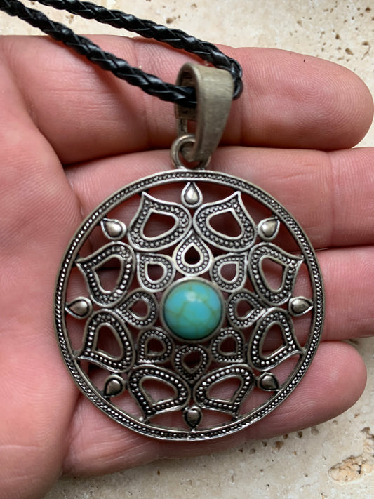 Pendentif en métal argenté en forme de Mandala avec cabochon d'howlite bleue au centre. De 48 x 12 millimètres. Vendu avec cordon noir réglable offert, parfait !