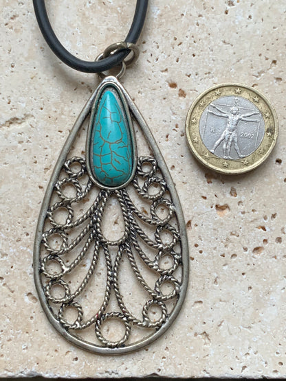 Pendentif en métal argenté en forme de Mandala avec cabochon d'howlite bleue au centre. De 80 millimètres de hauteur x 40 de largeur x 10 d'épaisseur. Vendu avec cordon noir réglable offert, parfait !