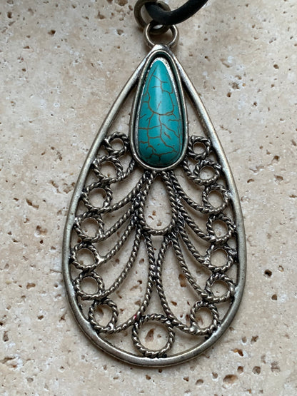 Pendentif en métal argenté en forme de Mandala avec cabochon d'howlite bleue au centre. De 80 millimètres de hauteur x 40 de largeur x 10 d'épaisseur. Vendu avec cordon noir réglable offert, parfait !