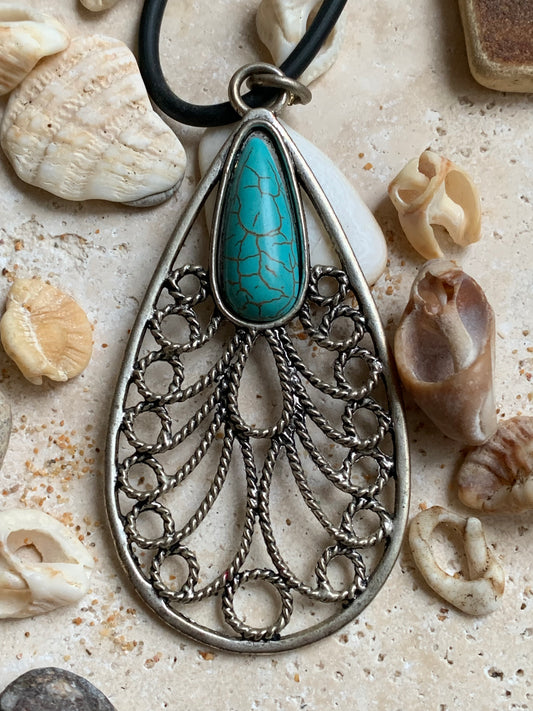 Pendentif en métal argenté en forme de Mandala avec cabochon d'howlite bleue au centre. De 80 millimètres de hauteur x 40 de largeur x 10 d'épaisseur. Vendu avec cordon noir réglable offert, parfait !