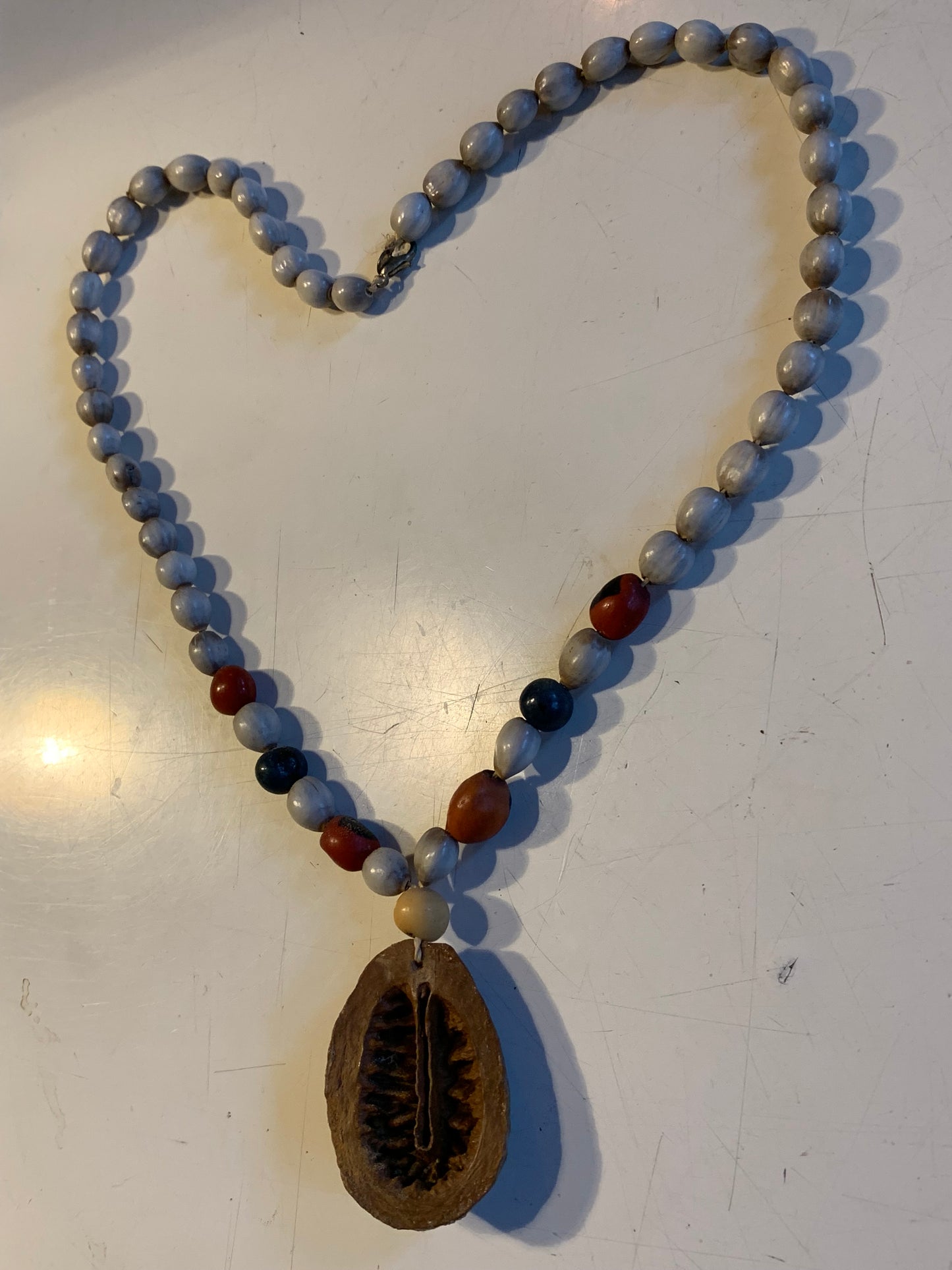 Collier du Pérou en graines naturelles, perles de ± 8 à 10 millimètres. Taille de 55 centimètres de longueur environ + pendentif (coque). Superbe pièce !