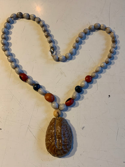 Collier du Pérou en graines naturelles, perles de ± 8 à 10 millimètres. Taille de 55 centimètres de longueur environ + pendentif (coque). Superbe pièce !