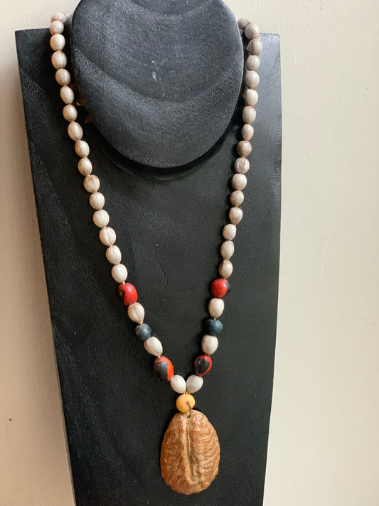 Peruvian necklace made of natural seeds, pearls measuring approximately 8 to 10 millimeters. Approximately 55 centimeters long, including the pendant (shell). A superb piece!