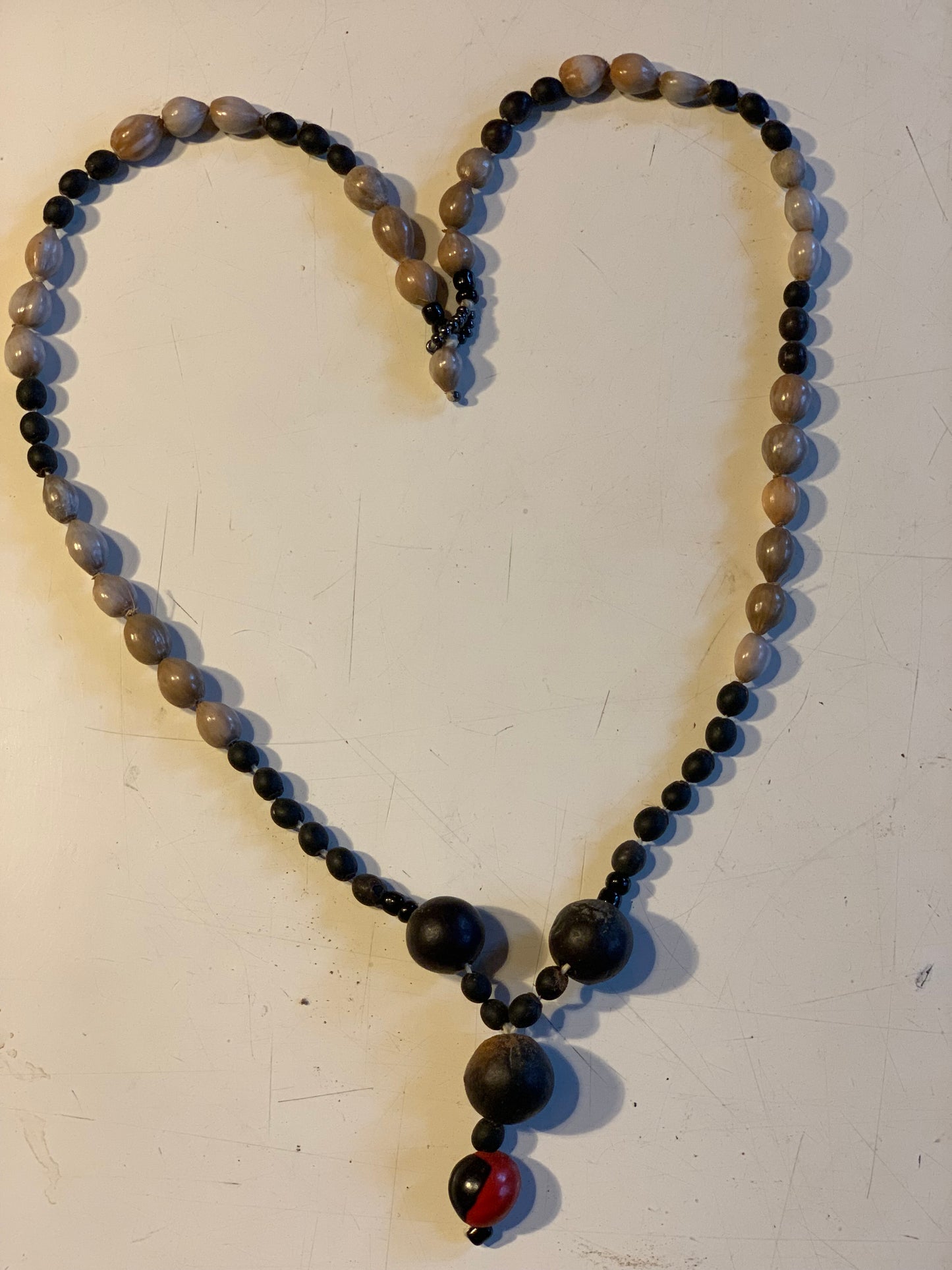 Collier du Pérou en graines naturelles, perles de ± 8 à 12 millimètres. Taille de 60 centimètres de longueur environ + pendentif de 30 mm(coque). Superbe pièce !