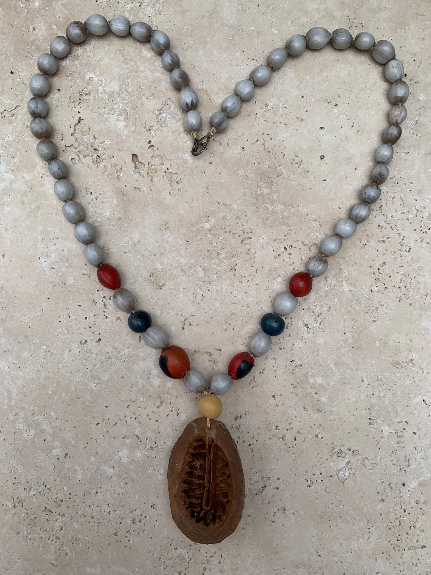 Collier du Pérou en graines naturelles, perles de ± 8 à 10 millimètres. Taille de 55 centimètres de longueur environ + pendentif (coque). Superbe pièce !