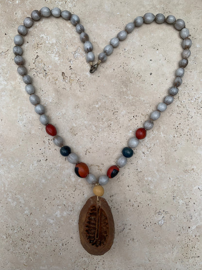 Collier du Pérou en graines naturelles, perles de ± 8 à 10 millimètres. Taille de 55 centimètres de longueur environ + pendentif (coque). Superbe pièce !