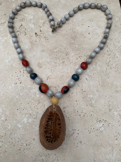 Collier du Pérou en graines naturelles, perles de ± 8 à 10 millimètres. Taille de 55 centimètres de longueur environ + pendentif (coque). Superbe pièce !