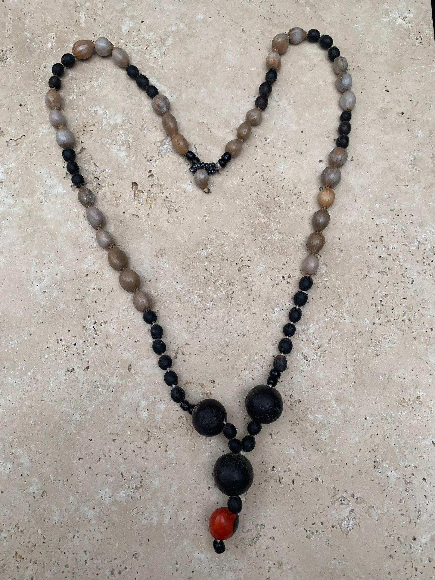 Collier du Pérou en graines naturelles, perles de ± 8 à 12 millimètres. Taille de 60 centimètres de longueur environ + pendentif de 30 mm(coque). Superbe pièce !