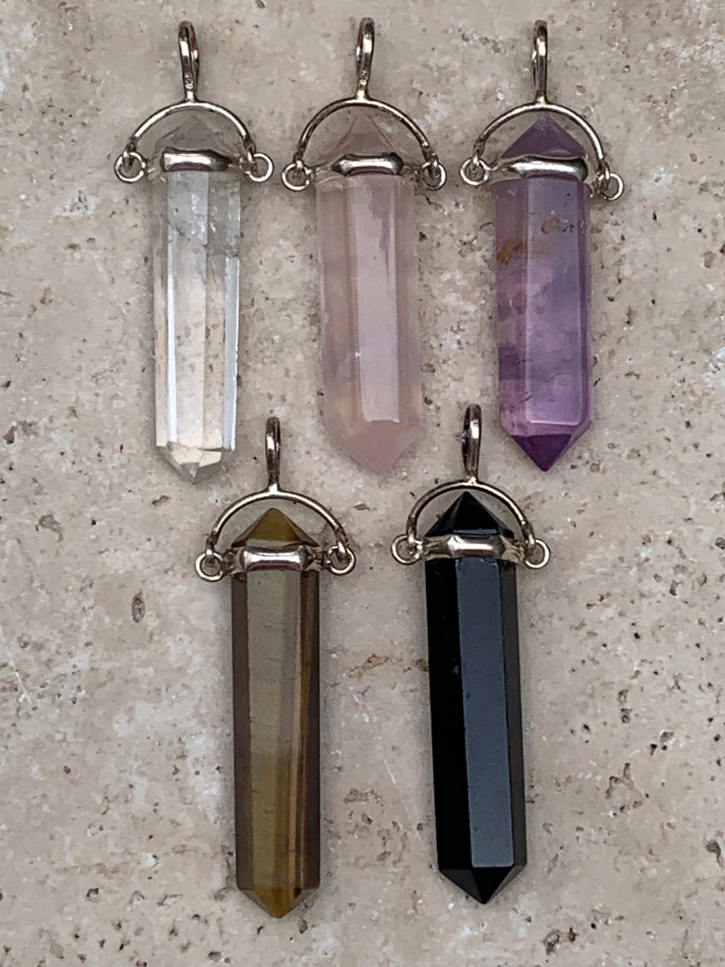 Pendentifs de cristaux 'laser' à pointe biterminée avec attache articulée, au choix : Cristal, quartz rose, améthyste, obsidienne, oeil de tigre ! De 37 millimètres x 8 millimètres de diamètre. Vendu avec cordon réglable de couleur noire !