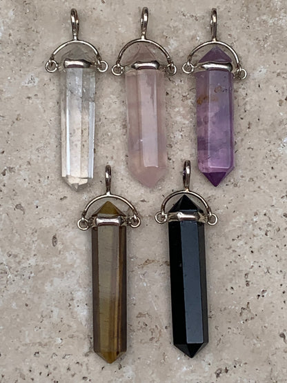 Pendentifs de cristaux 'laser' à pointe biterminée avec attache articulée, au choix : Cristal, quartz rose, améthyste, obsidienne, oeil de tigre ! De 37 millimètres x 8 millimètres de diamètre. Vendu avec cordon réglable de couleur noire !