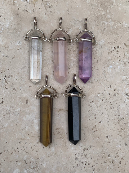 Pendentifs de cristaux 'laser' à pointe biterminée avec attache articulée, au choix : Cristal, quartz rose, améthyste, obsidienne, oeil de tigre ! De 37 millimètres x 8 millimètres de diamètre. Vendu avec cordon réglable de couleur noire !
