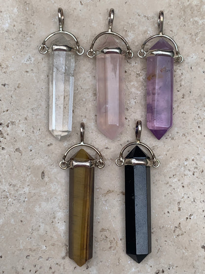 Pendentifs de cristaux 'laser' à pointe biterminée avec attache articulée, au choix : Cristal, quartz rose, améthyste, obsidienne, oeil de tigre ! De 37 millimètres x 8 millimètres de diamètre. Vendu avec cordon réglable de couleur noire !