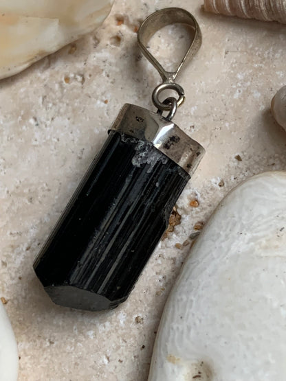 Aquamarine pendant set in silver with a metal design! Unique piece measuring 38 millimeters high x 12 millimeters wide x 8 millimeters thick. Sold with an adjustable black cord. Made in Pakistan!