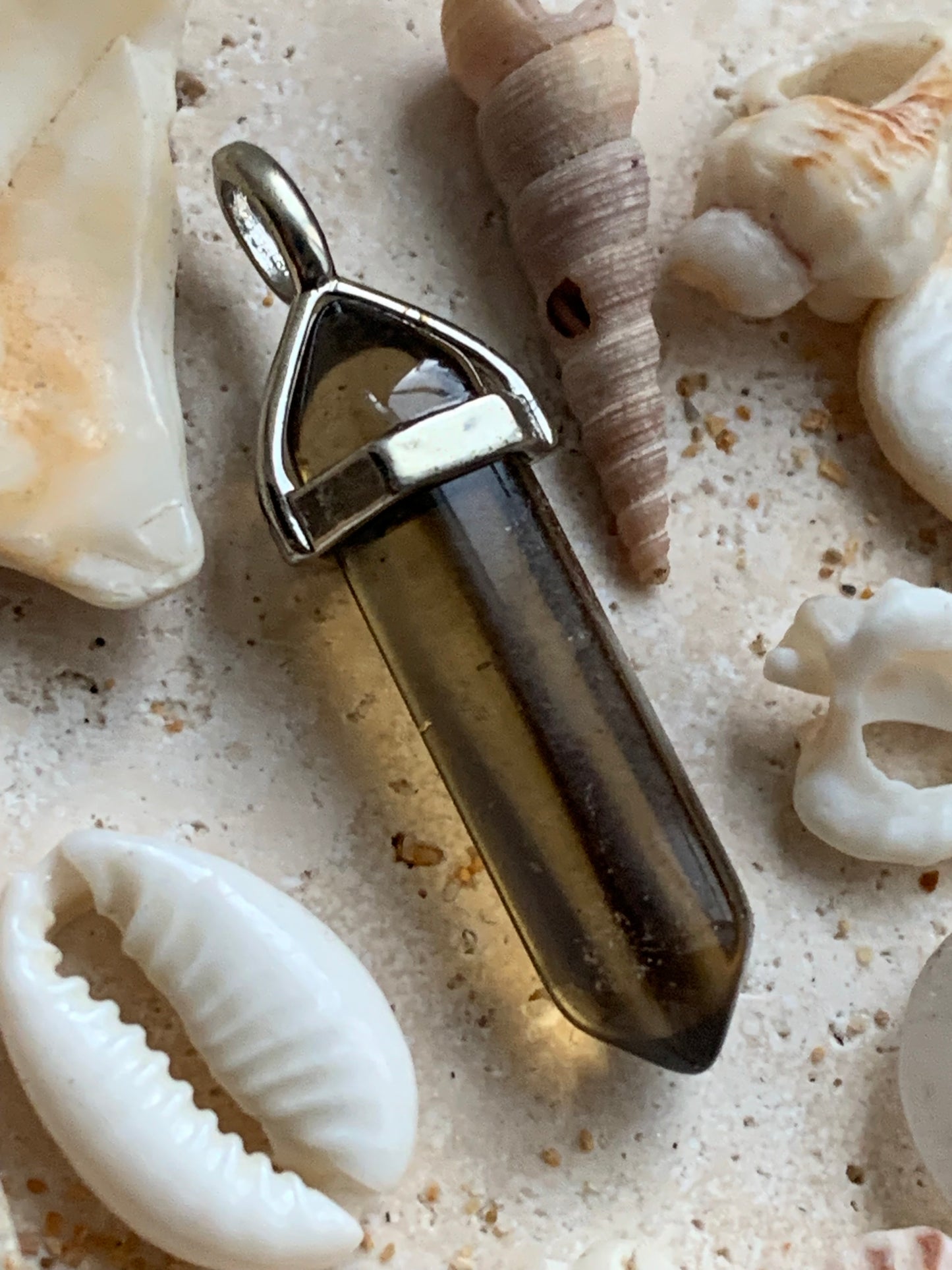 Cristal de roche fumé/ quartz fumé bi-déterminé, pendentif de 41mm x8 x8. Fait sur métal (laiton), finition argenté. Vendu avec cordon réglable de couleur noire !