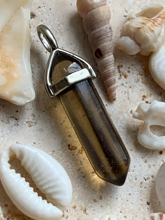 Cristal de roche fumé/ quartz fumé bi-déterminé, pendentif de 41mm x8 x8. Fait sur métal (laiton), finition argenté. Vendu avec cordon réglable de couleur noire !