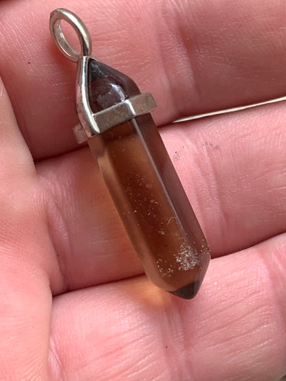 Cristal de roche fumé/ quartz fumé bi-déterminé, pendentif de 41mm x8 x8. Fait sur métal (laiton), finition argenté. Vendu avec cordon réglable de couleur noire !