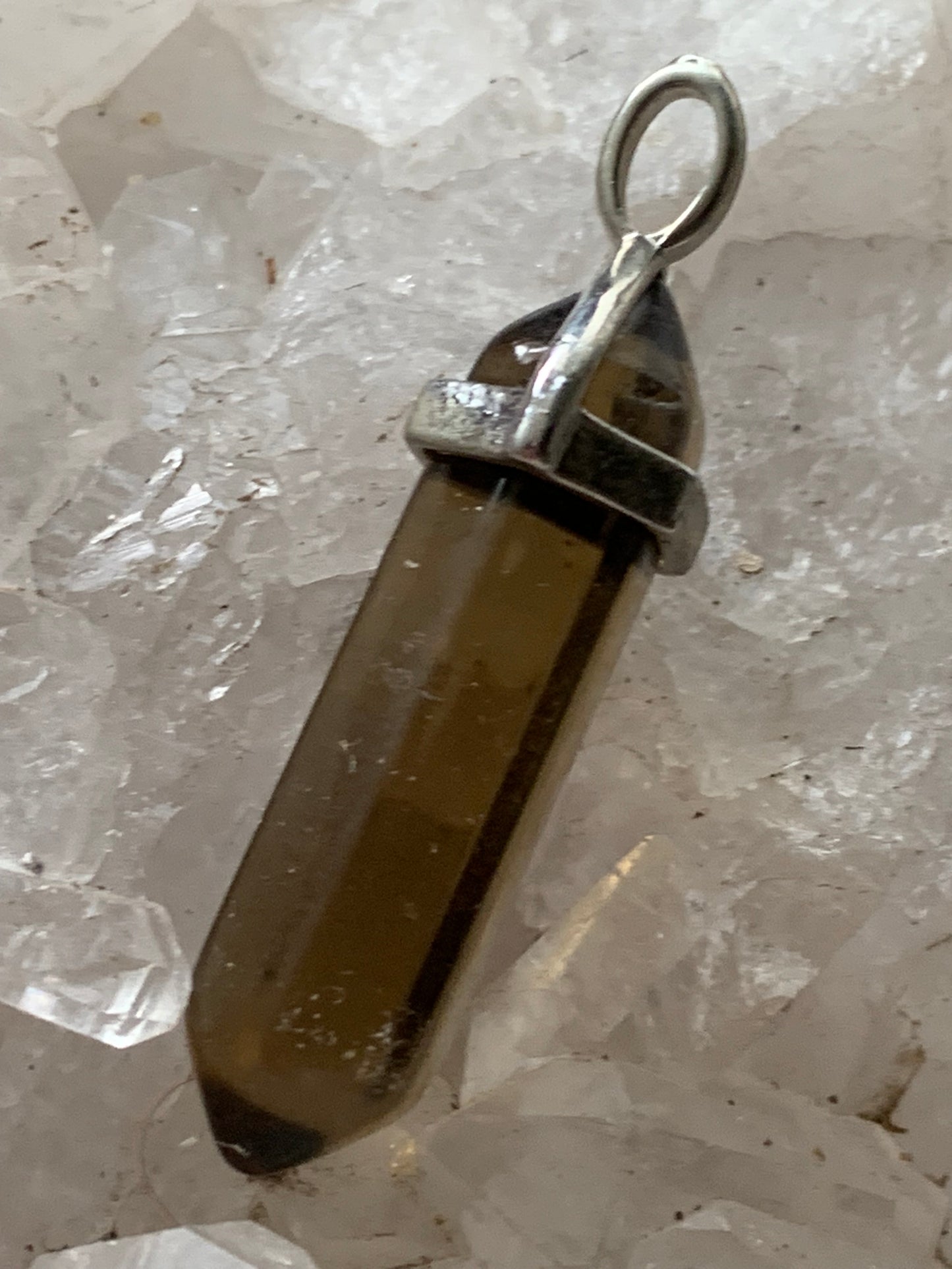 Cristal de roche fumé/ quartz fumé bi-déterminé, pendentif de 41mm x8 x8. Fait sur métal (laiton), finition argenté. Vendu avec cordon réglable de couleur noire !