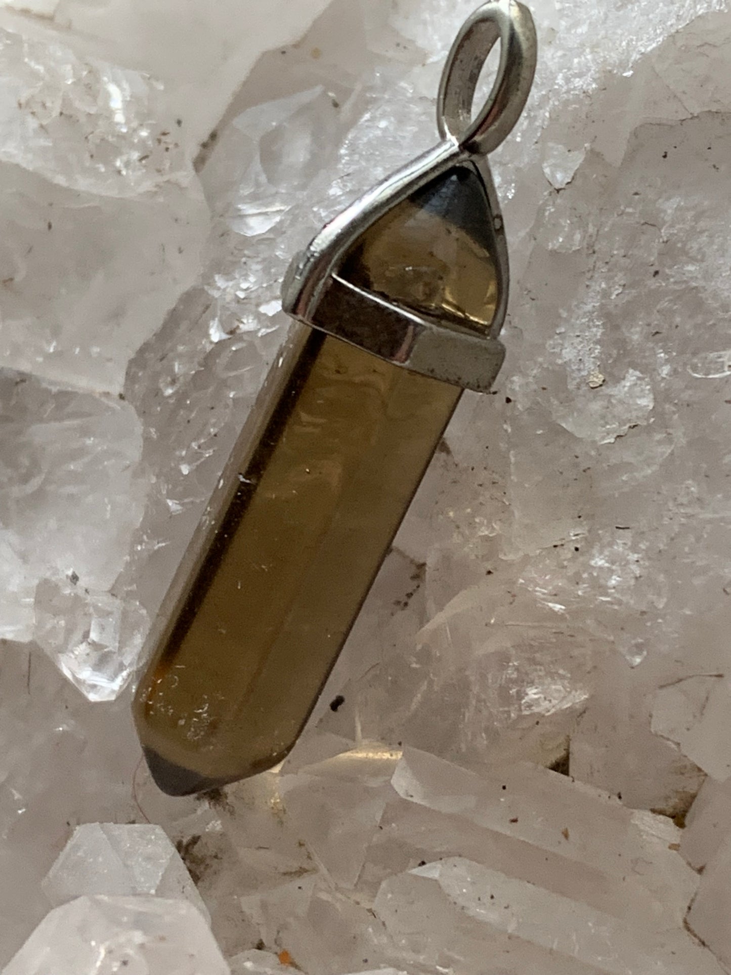 Cristal de roche fumé/ quartz fumé bi-déterminé, pendentif de 41mm x8 x8. Fait sur métal (laiton), finition argenté. Vendu avec cordon réglable de couleur noire !