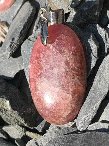 Rhodochrosite, 'cabochon percé' de 40 mm x 18 x 6. Vendu avec un cordon réglable de couleur noire !