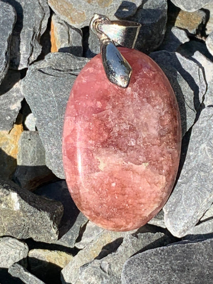 Rhodochrosite, 'cabochon percé' de 40 mm x 18 x 6. Vendu avec un cordon réglable de couleur noire !