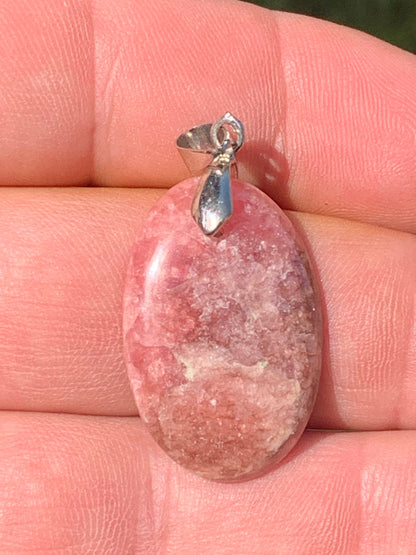 Rhodochrosite, 'cabochon percé' de 40 mm x 18 x 6. Vendu avec un cordon réglable de couleur noire !