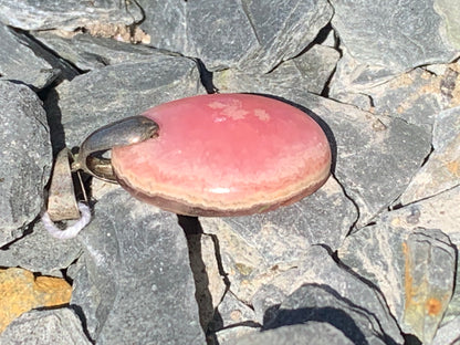 Rhodochrosite, 'cabochon percé' de 37 mm x 17 x 6. Vendu avec un cordon réglable de couleur noire !
