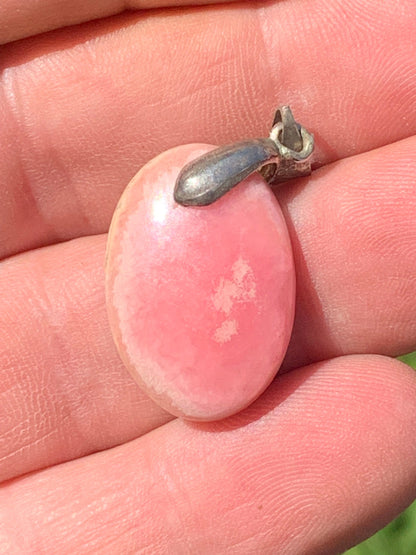 Rhodochrosite, 'cabochon percé' de 37 mm x 17 x 6. Vendu avec un cordon réglable de couleur noire !