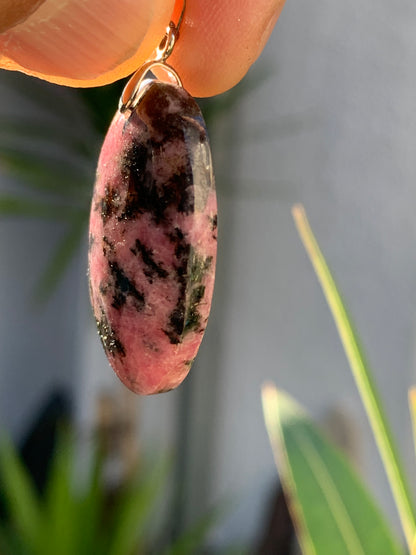 Rhodonite, pendentif 'cabochon percé' de 39mm x23 x7. Vendu avec cordon réglable de couleur noire !