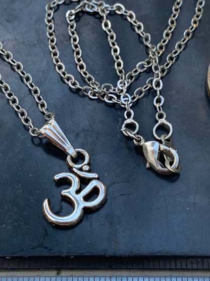 Om, pendentif en laiton argenté, de 23x12x2 millimètres -1,3 gr. Vendu avec cordon noir réglable offert, parfait !