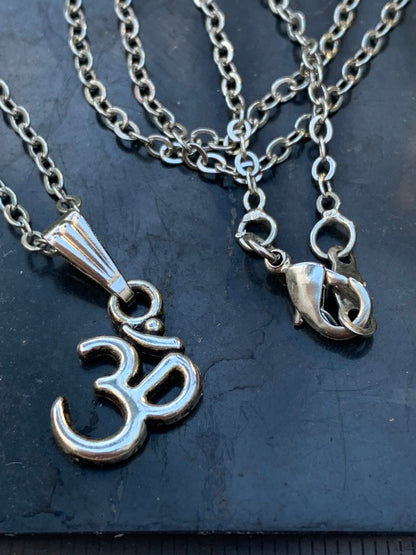 Om, pendentif en laiton argenté, de 23x12x2 millimètres -1,3 gr. Vendu avec cordon noir réglable offert, parfait !