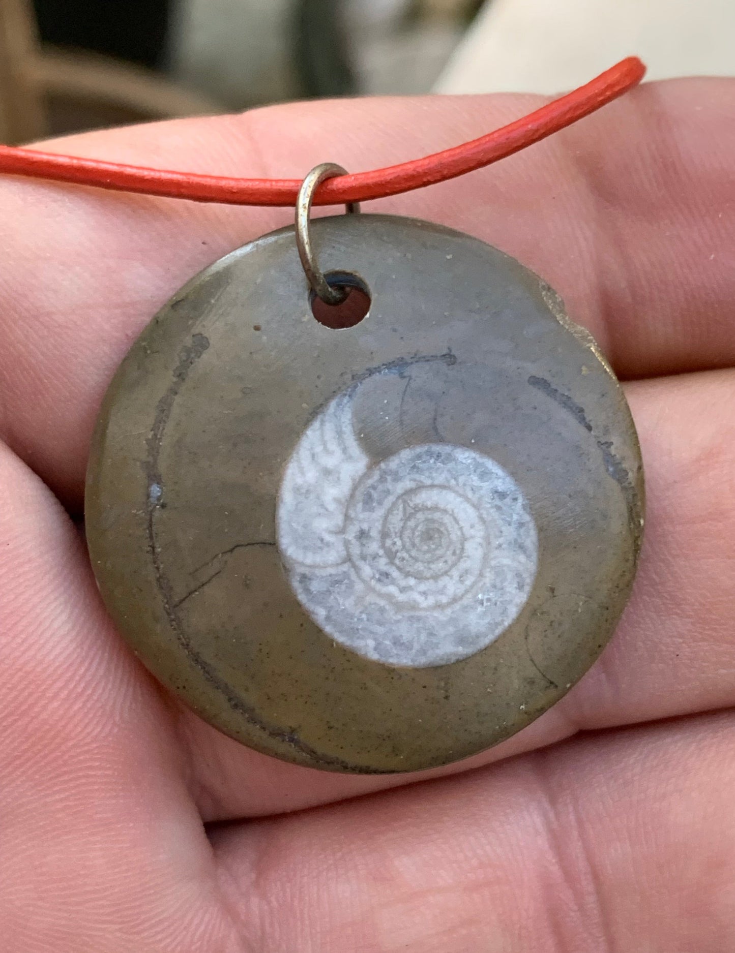 Ammonite fossile dans grès rouge (Usa), pendentif de 33 millimètres x 6. Vendu avec cordon noir et réglable de 60 cm !