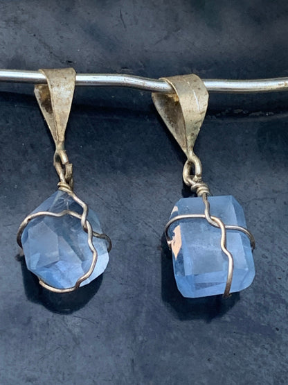 Topaze bleue, 2 pendentifs au choix en Argent, de 26mm de hauteur x 9 de largeur x 9 d'épaisseur. Vendu avec cordon réglable de couleur noire offert !