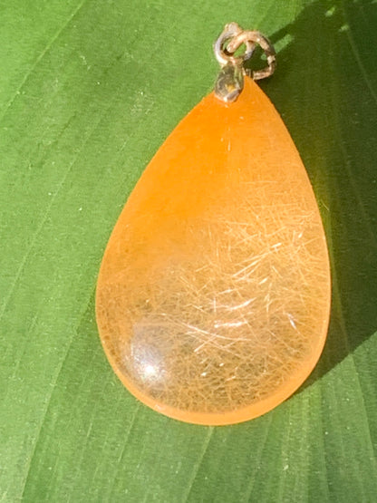Rock crystal/quartz with golden rutile inclusions! Silver pendant, 33 mm high x 18 mm wide x 5 mm thick. Sold with an adjustable black cord!