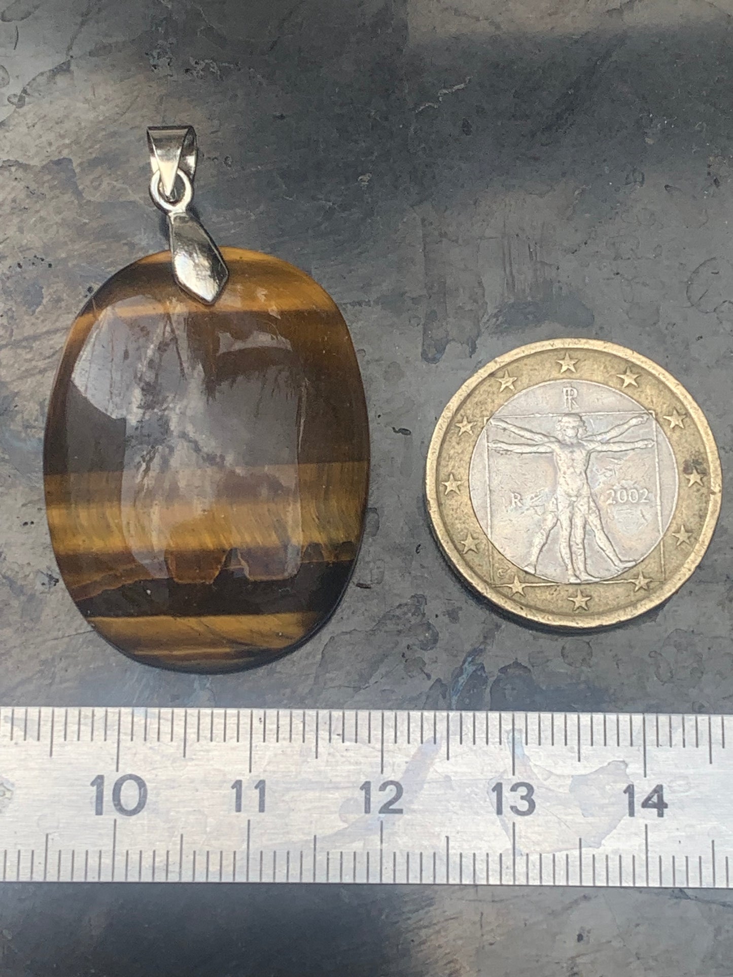 Tiger's Eye pendant measuring 42mm high x 25mm wide x 7mm thick. Comes with a free adjustable black cord!