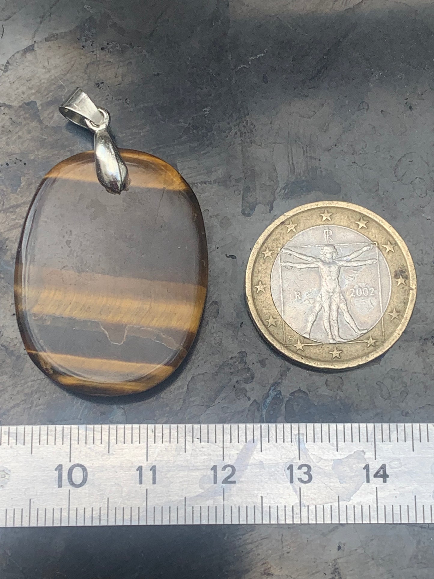 Tiger's Eye pendant measuring 42mm high x 25mm wide x 7mm thick. Comes with a free adjustable black cord!