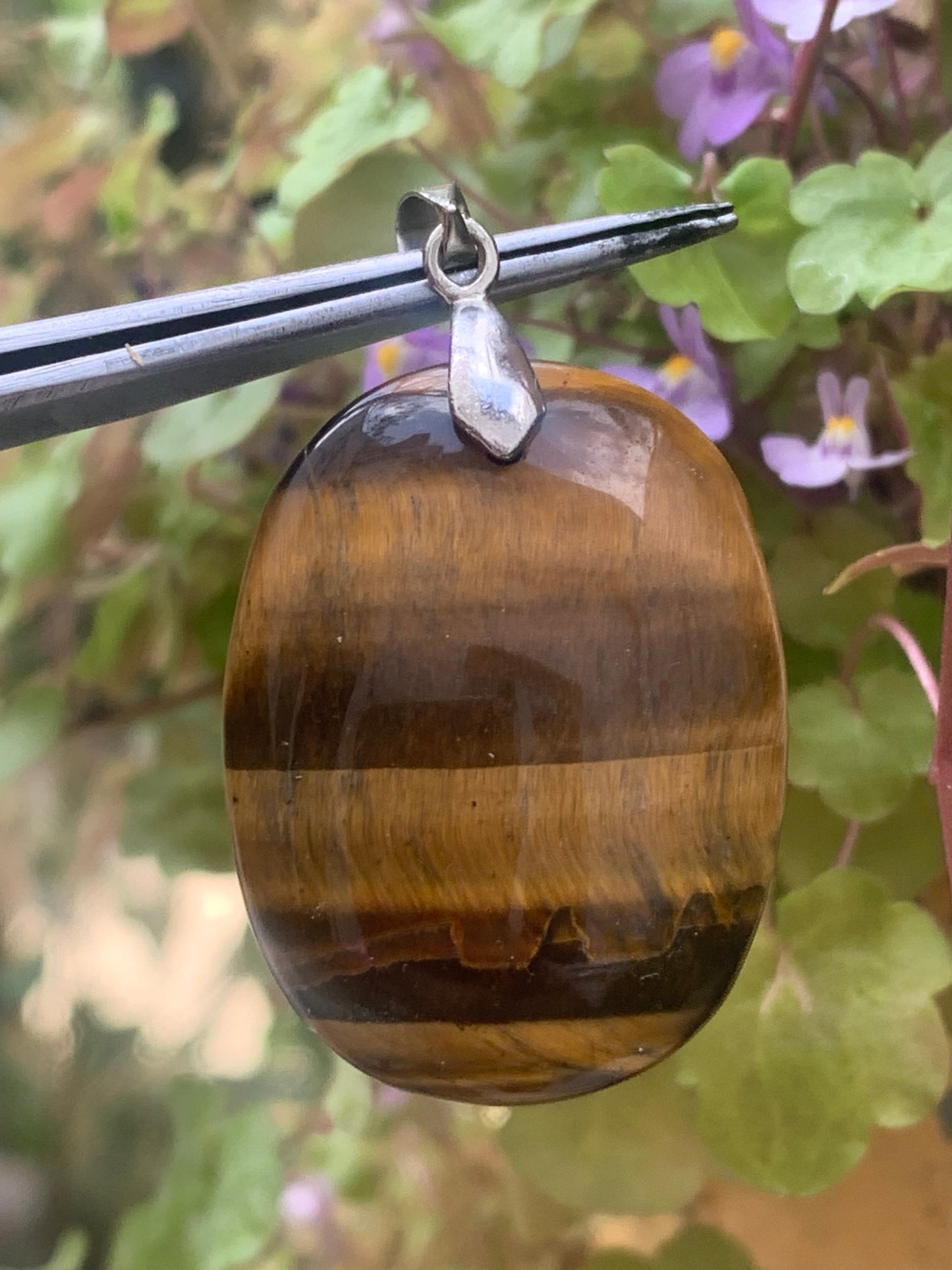 Tiger's Eye pendant measuring 42mm high x 25mm wide x 7mm thick. Comes with a free adjustable black cord!