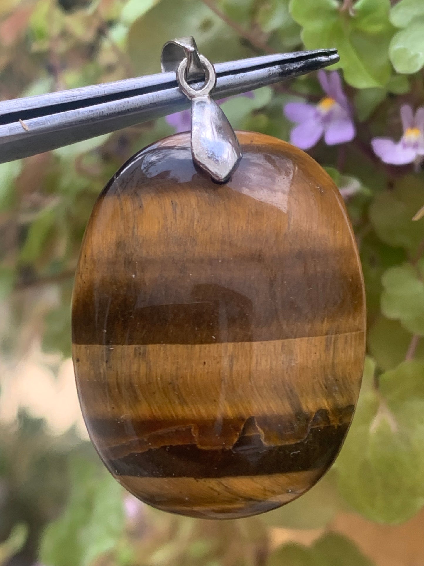 Tiger's Eye pendant measuring 42mm high x 25mm wide x 7mm thick. Comes with a free adjustable black cord!