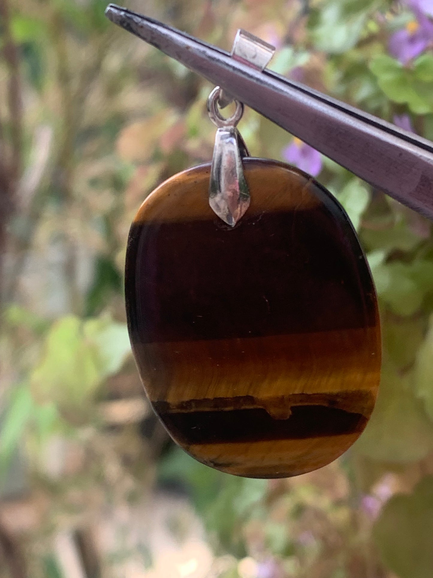 Tiger's Eye pendant measuring 42mm high x 25mm wide x 7mm thick. Comes with a free adjustable black cord!