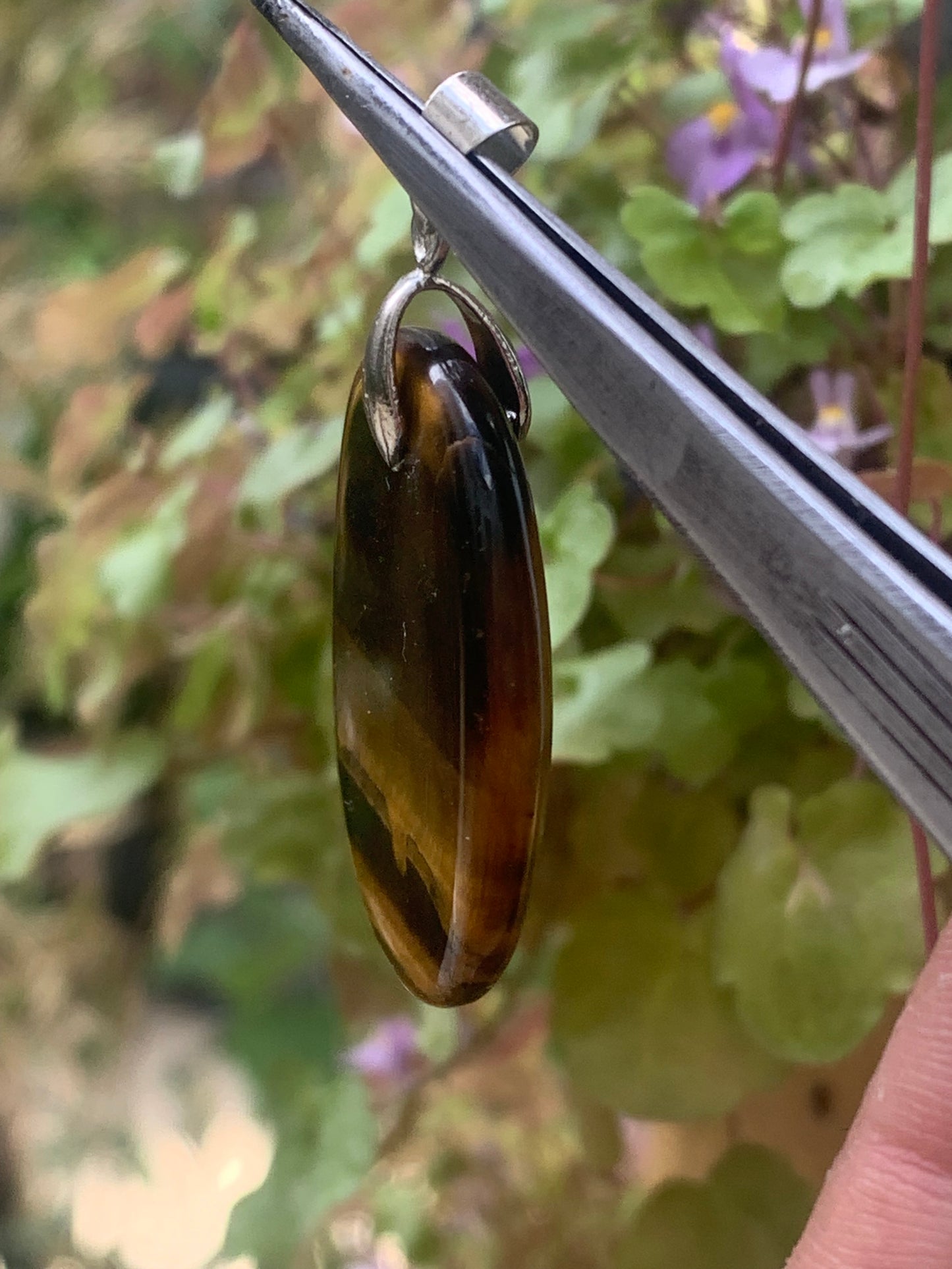 Tiger's Eye pendant measuring 42mm high x 25mm wide x 7mm thick. Comes with a free adjustable black cord!