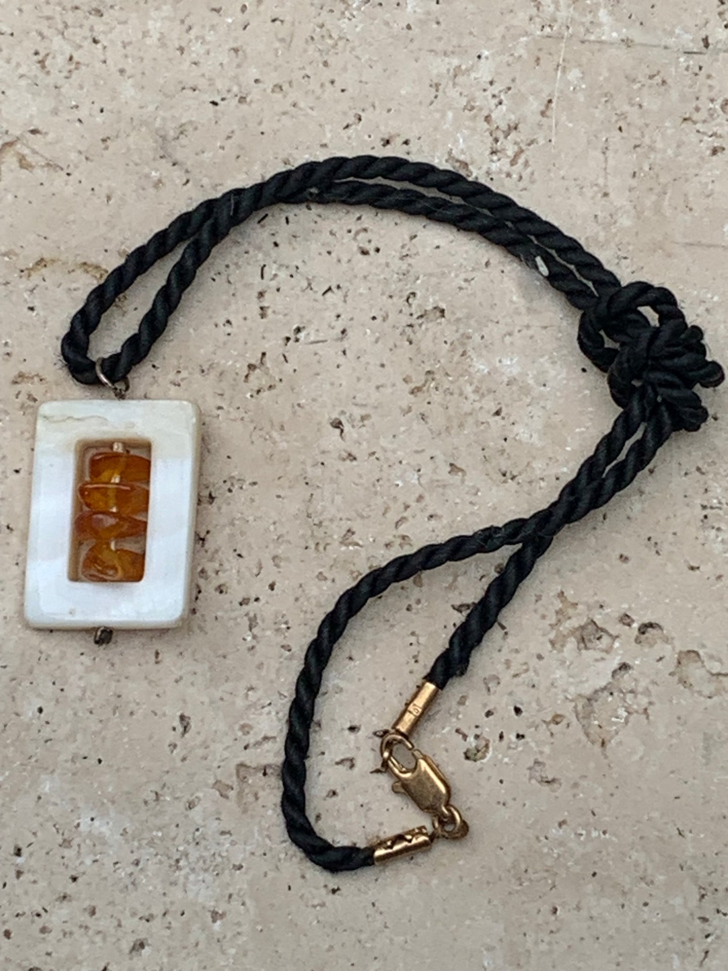 Amber and mother-of-pearl, pendant measuring 31x17x9 millimeters, sold with a sliding (adjustable) black leather cord measuring 40 to 70 centimeters!