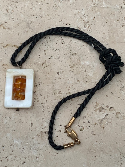 Amber and mother-of-pearl, pendant measuring 31x17x9 millimeters, sold with a sliding (adjustable) black leather cord measuring 40 to 70 centimeters!