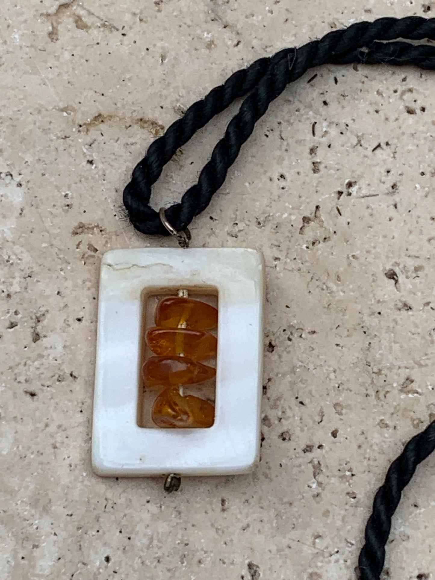 Amber and mother-of-pearl, pendant measuring 31x17x9 millimeters, sold with a sliding (adjustable) black leather cord measuring 40 to 70 centimeters!