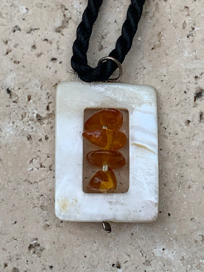 Amber and mother-of-pearl, pendant measuring 31x17x9 millimeters, sold with a sliding (adjustable) black leather cord measuring 40 to 70 centimeters!